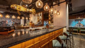 Modern bar interior at Sheraton Cairo with hanging lights, fish sculpture, and mural.