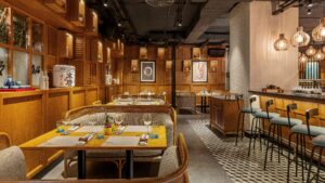 Sheraton Cairos modern restaurant features wooden decor, set tables, and a sleek bar area.