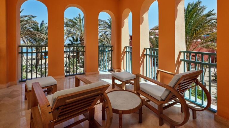 Sheraton Miramar Resort: Balcony with wooden lounge chairs and ocean view through arched openings.