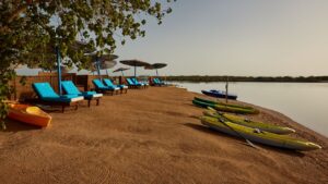 Relax at Sheraton Miramar Resorts beach with lounge chairs, umbrellas, and kayaks by calm waters.
