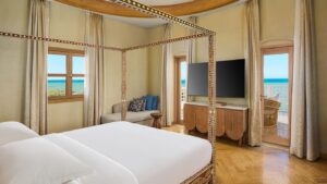 Canopy bed, TV, and ocean view at Sheraton Miramar Resort.