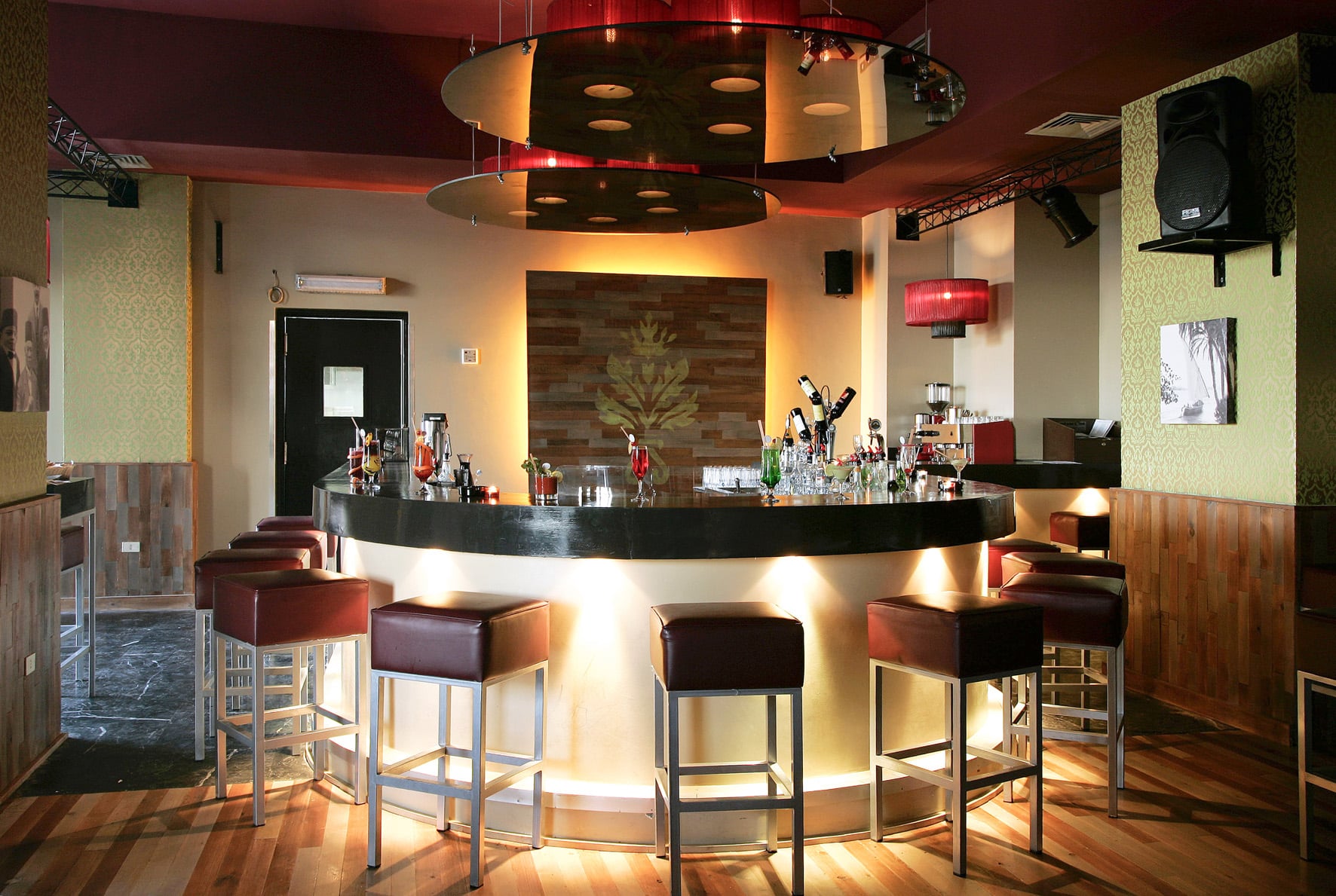 Three Corners Ocean View bar with a circular counter, stools, and bottles on display.