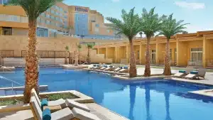 Outdoor pool with lounge chairs and palm trees at Hilton Hurghada hotel.