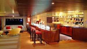 MS Classic bar with stools, bottles on shelves, and a person behind the counter.
