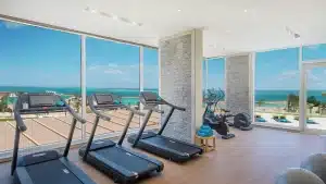 Hilton Hurghada fitness room with treadmills, ellipticals, and a sea view through large windows.
