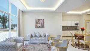 Elegant Hilton Hurghada living room with patterned sofas, armchairs, dining table, and kitchen.
