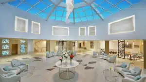 Hilton Hurghadas lobby boasts a skylight, modern seating, and a central floral arrangement.