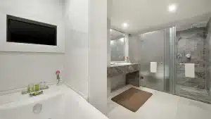 Modern Hilton Hurghada bathroom with a bathtub, glass shower, and mirror-adorned sink.