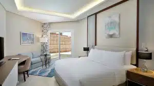 Hilton Hurghada room with king bed, sofa, and sliding doors to the patio.