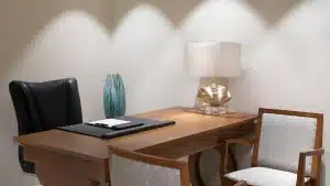 Hilton Hurghada office: modern setup with a wooden desk, black chair, lamp, vase, and notepad.
