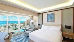Hilton Hurghada hotel room with a large bed, sea view, and modern decor.