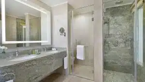 Modern bathroom at Hilton Hurghada with a glass shower and granite countertops.