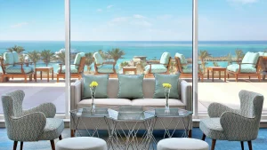 Lounge at Hilton Hurghada with sofas, chairs, and a sea view through large glass windows.