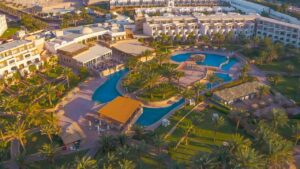 Aerial view of Fort Arabesque Resort with pools, palm trees, and landscaped buildings.