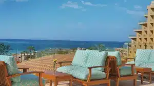 Outdoor seating at Hilton Hurghada with blue cushions, overlooking the sea and palm trees.