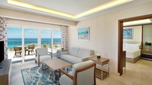 Hilton Hurghada hotel room with a seating area, ocean view balcony, and bedroom.