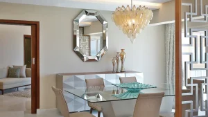 Modern dining room at Hilton Hurghada with glass table, chandelier, mirror, and vases.