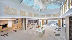 Spacious Hilton Hurghada lobby with skylight, modern decor, and a floral centerpiece table.