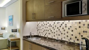 Hilton Hurghadas modern kitchenette boasts a tiled backsplash and marble countertop.