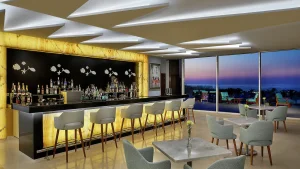 Modern bar with illuminated counter, stylish chairs, and ocean view at Hilton Hurghada.