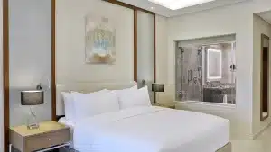Hilton Hurghada room with a bed, two lamps, and a view into a modern bathroom.