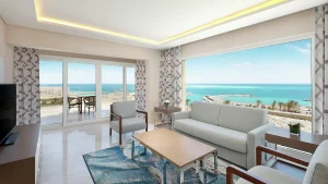Modern living room at Hilton Hurghada, ocean view through large windows, neutral tones.