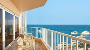 Balcony at Hurghada Marriott Beach Resort overlooks a calm sea and boats under a clear blue sky.