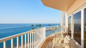 Balcony view of a calm ocean at Hurghada Marriott, with palm trees and a clear blue sky.