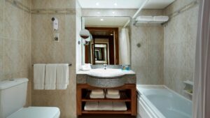 Hotel bathroom at Hurghada Marriott Beach Resort with a mirror, sink, tub, and fluffy towels.