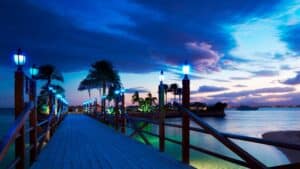 Pier at Hurghada Marriott, blue lights, palm trees, calm sea under dramatic evening sky.