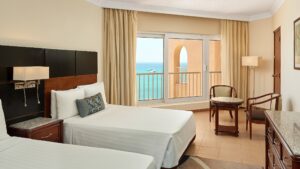 Room with two beds, ocean view, and seating area at Hurghada Marriott Beach Resort.