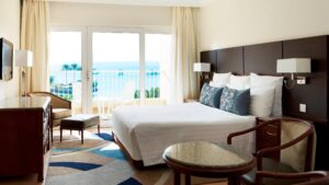 Room with a double bed, chairs, and a sea view balcony at Hurghada Marriott Beach Resort.