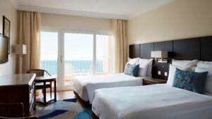 Hotel room at Hurghada Marriott with two beds, a desk, a TV, and an ocean-view balcony.