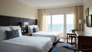 Hotel room with two beds, large window, and ocean view at Hurghada Marriott Beach Resort.