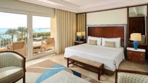 Hurghada Marriott Beach Resort room with a king bed, seating, and balcony overlooking the beach.