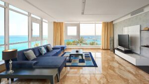 Modern living room at Hurghada Marriott with blue sofa, ocean view, and large windows.