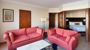 Room at Hurghada Marriott Beach Resort with red sofas, a bed, wooden doors, and framed wall art.