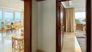 Hurghada Marriott suite with dining table, glass door, and ocean view balcony.