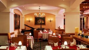 Elegant restaurant at Hurghada Marriott with red tablecloths, chandeliers, and a grand piano.