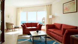 Living room with red sofas, coffee table, and ocean view like at Hurghada Marriott Beach Resort.