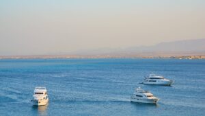 Three white yachts near the distant coastline of Hurghada Marriott Beach Resort.