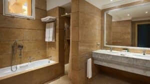 Elegant bathroom at Sheraton Soma Bay with a bathtub, shower, dual sinks, and towels on a rack.