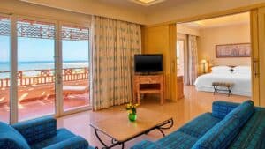 Sheraton Soma Bay hotel room with ocean view, seating area, and comfy bed.