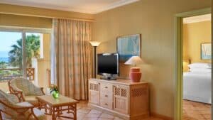 Sheraton Soma Bay room with TV, chairs, and an ocean-view window.
