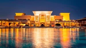Illuminated Sheraton Soma Bay reflects on calm waters at night.