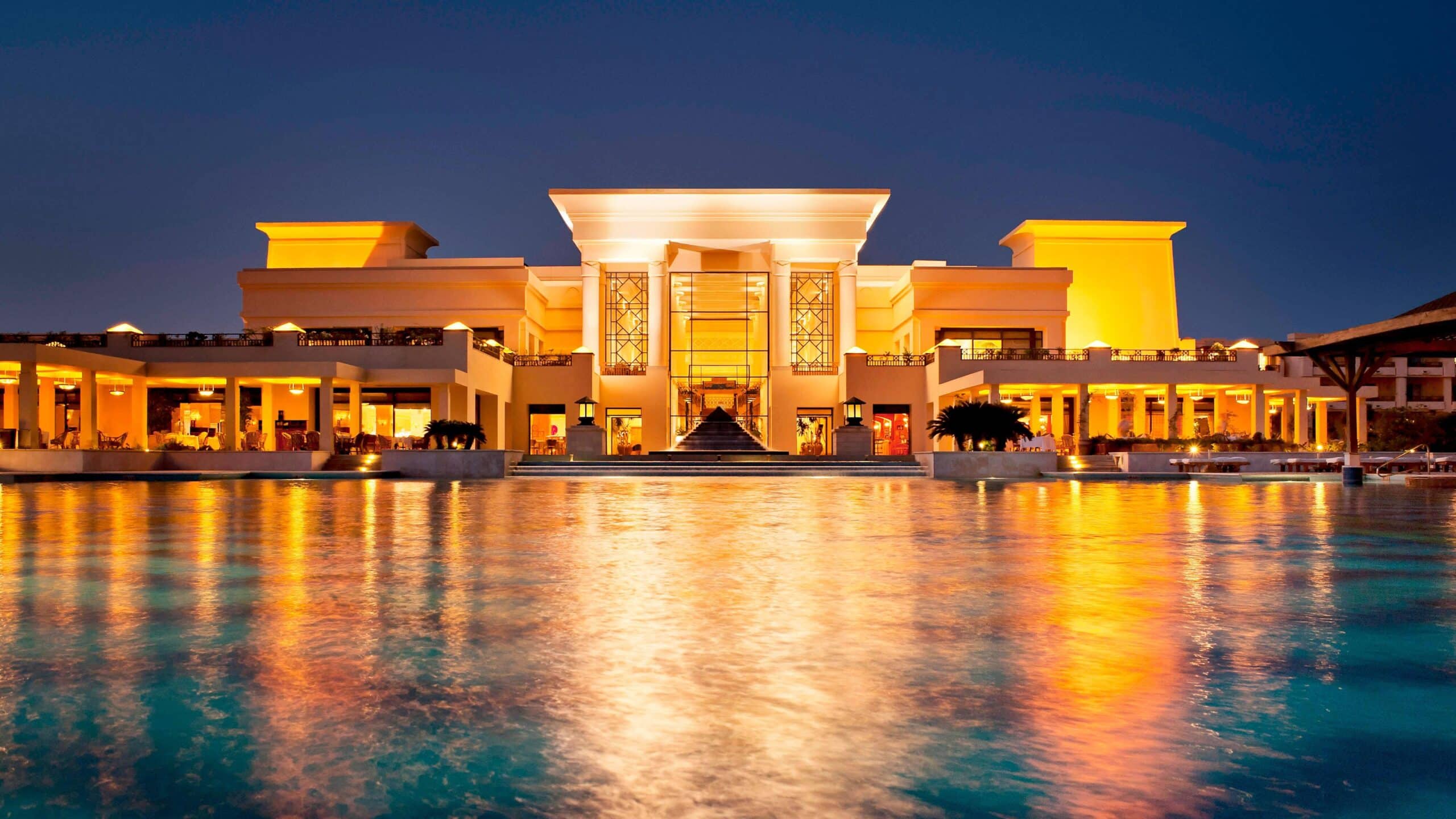 Illuminated Sheraton Soma Bay reflects on calm waters at night.