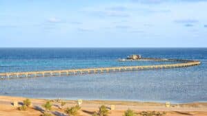 Sheraton Soma Bays curved pier stretches into the clear blue sea and sky.