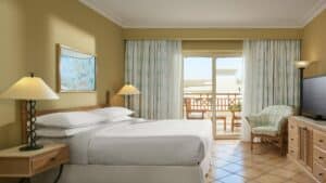 Sheraton Soma Bay room with bed, nightstand, lamp, TV, and balcony view.