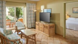 Sheraton Soma Bay room: seating area, TV, bed; patio doors lead to a garden view.