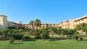 A landscaped garden with palm trees and the Sheraton Soma Bay in the background.